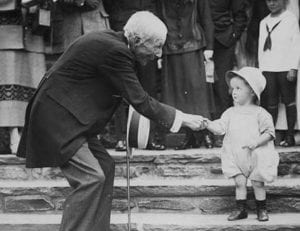 John D. Rockefeller, Sr. offers a dime to a young child (1924).